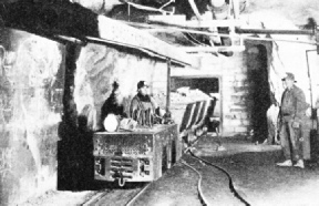 CAR LOADS OF GOLD-BEARING ORE are hauled by electric trolley locomotives in the various levels of Hollinger Gold Mine